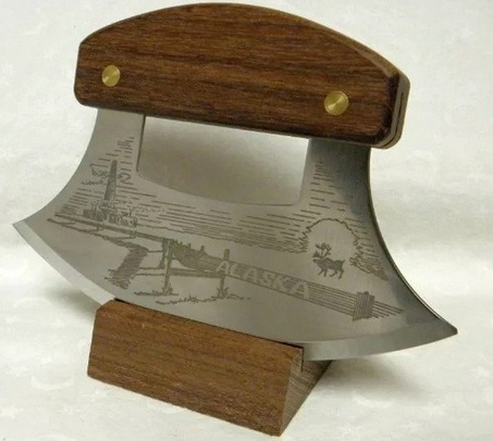 The ULU Factory knife with a decorated handle in a holding stand