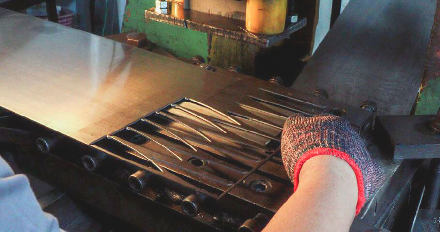 a knife stamping machine being operated by a bladesmith